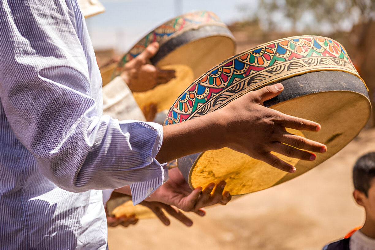 Berber musicians performing traditional music around a desert campfire in Merzouga